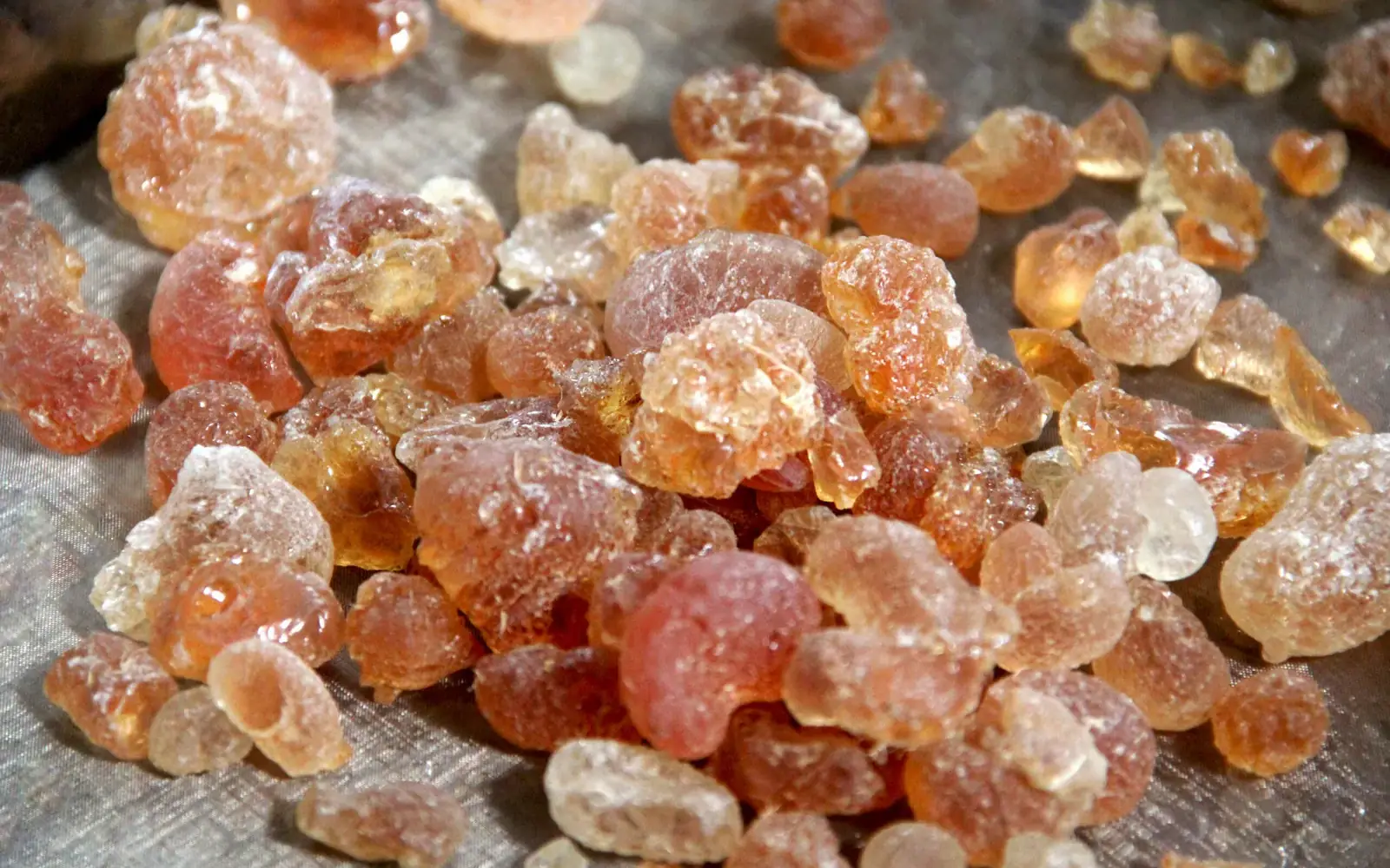 Vue de dessus d’un tas de nodules de gomme arabique de qualité alimentaire sur une surface métallique.