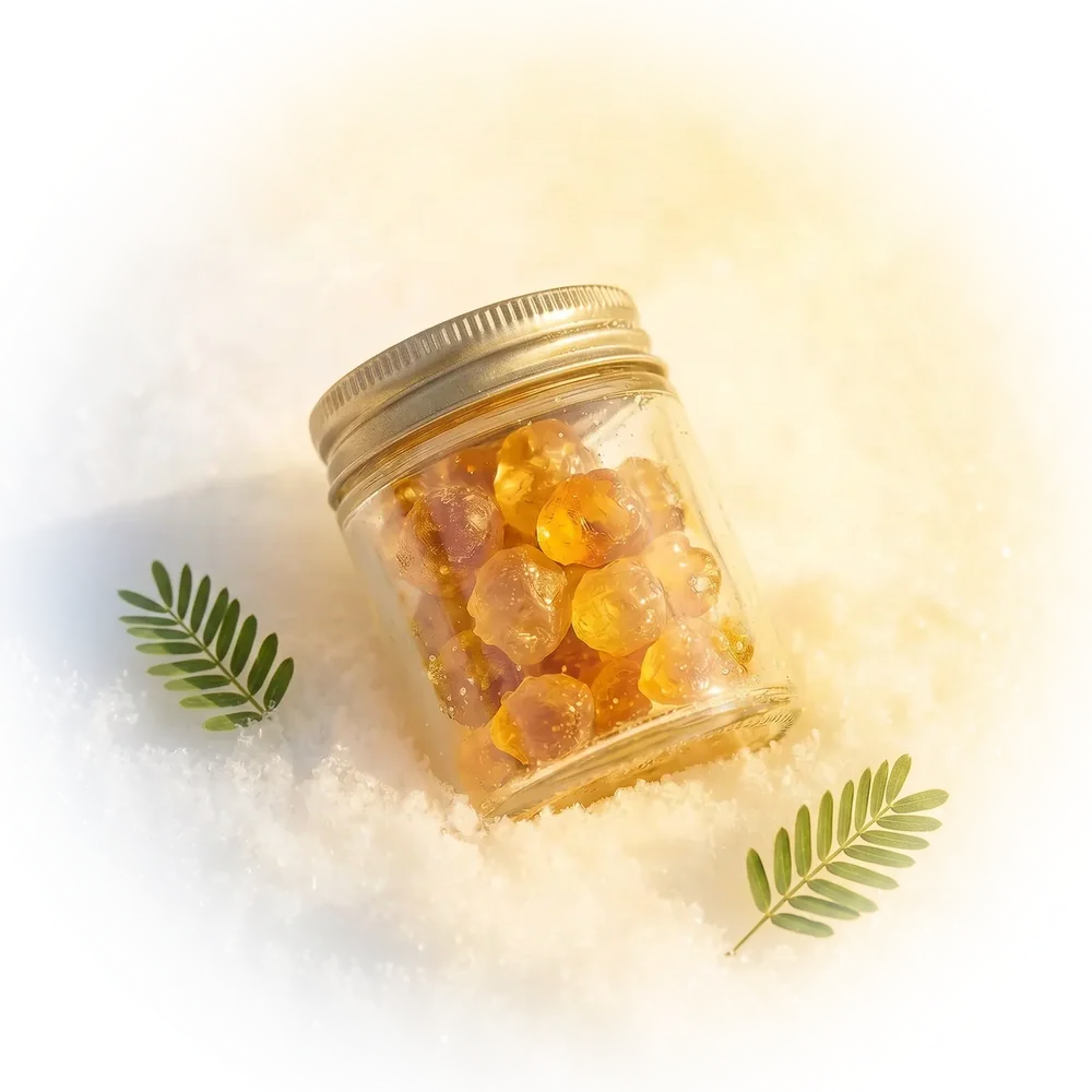 A glass jar of gum arabic powder standing on sand